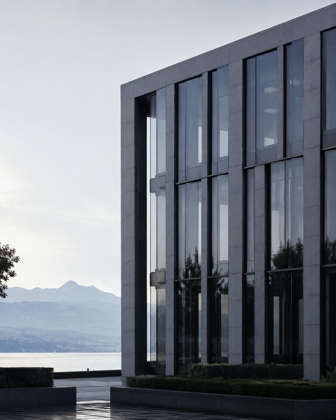 Moderne Fassade des Neosilk Firmensitzes in Zug aus Naturstein und Glas im Morgenlicht